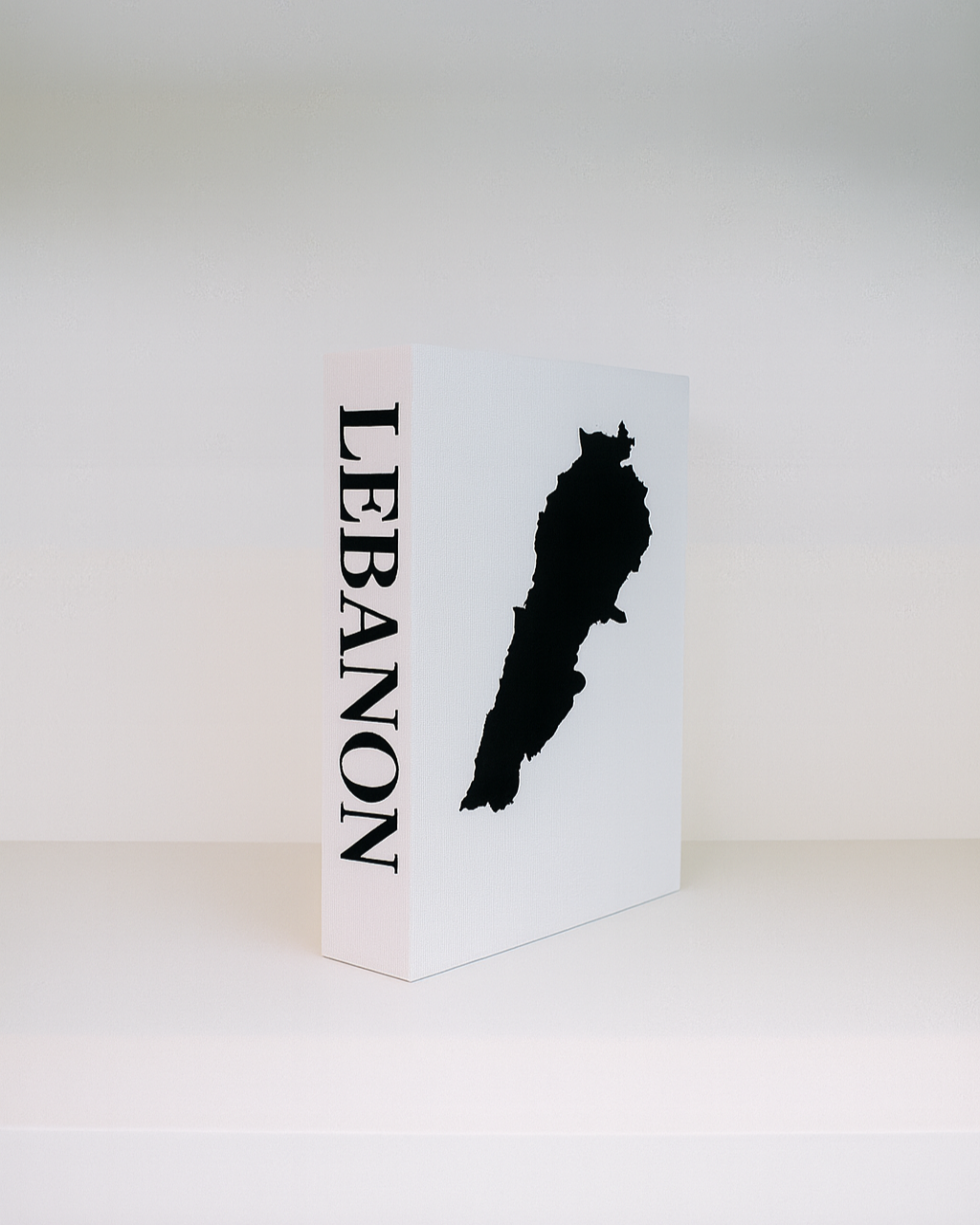 White box with black silhouette of Lebanon and 'LEBANON' text on a white background