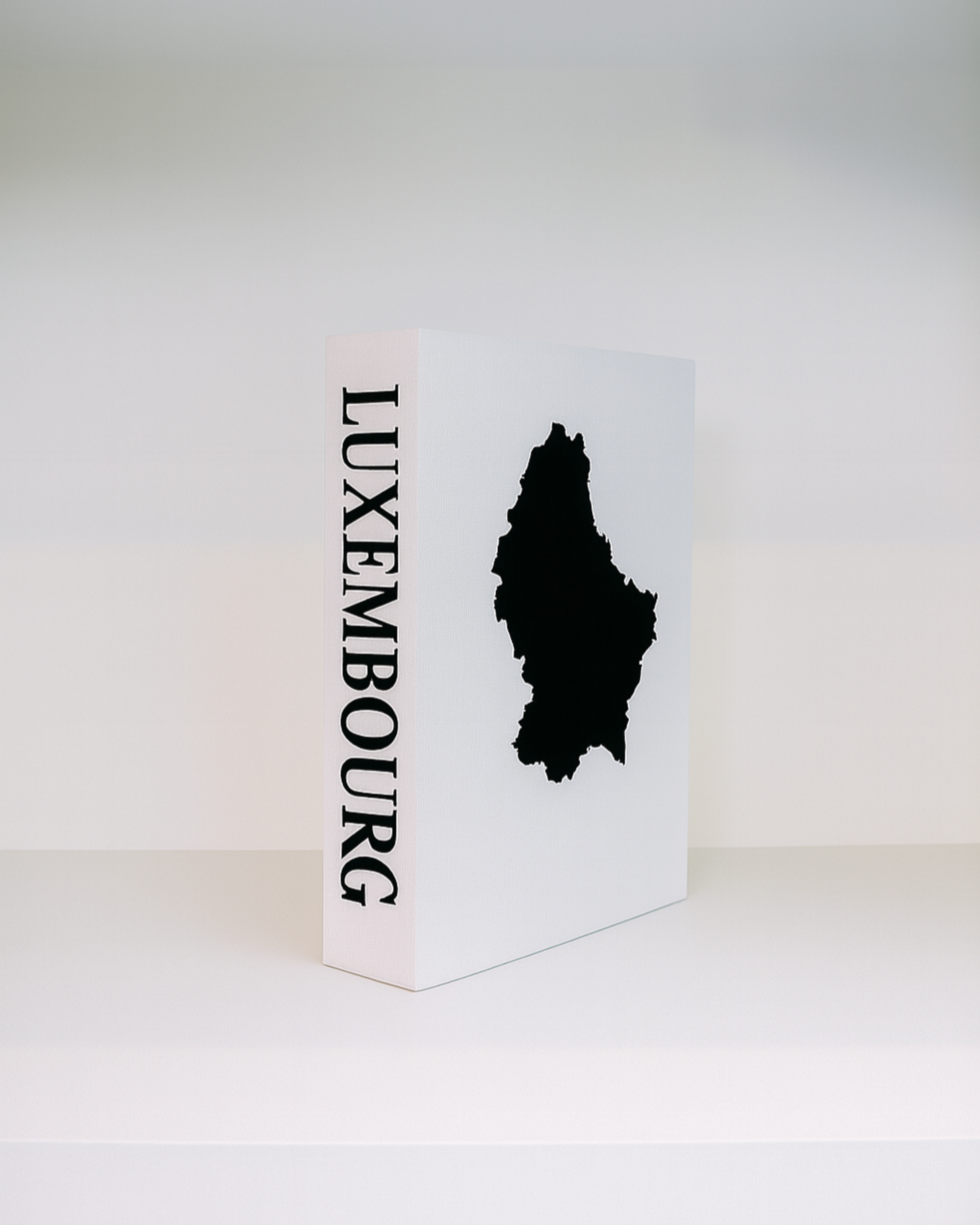 White box with black silhouette of Luxembourg and 'LUXEMBOURG' text on a white background