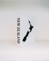 White box with black silhouette of New Zealand and 'NEW ZEALAND' text on a white background