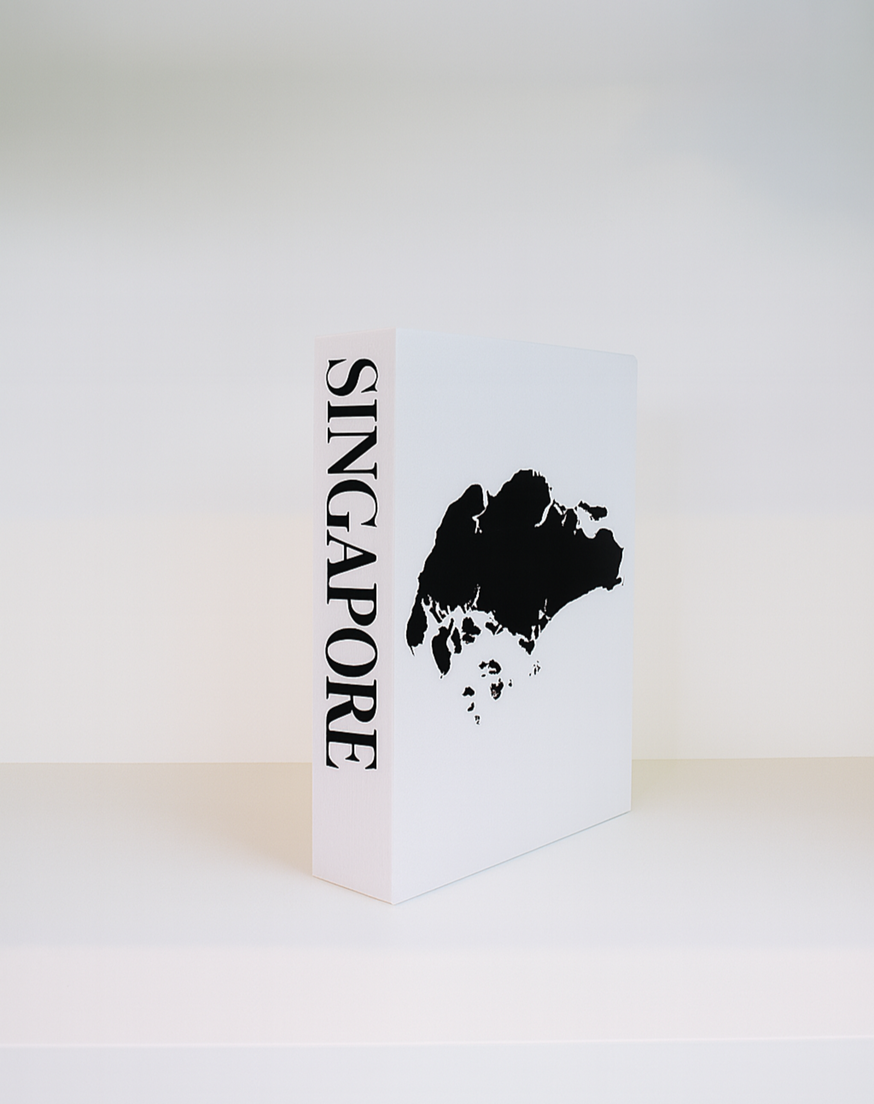 White book with black silhouette of Singapore and 'Singapore' text on a white background