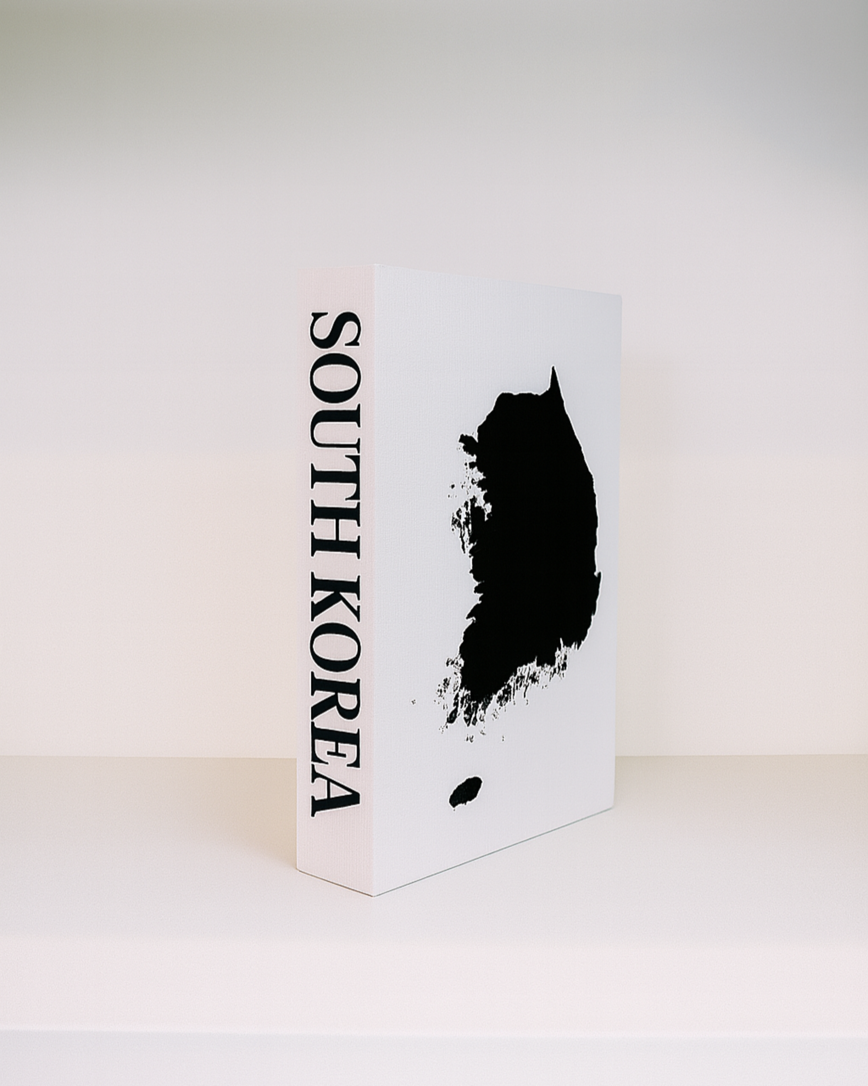 White book with black silhouette of South Korea and 'SOUTH KOREA' text on a white background