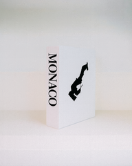 White book with 'MONACO' and a black silhouette on a white background